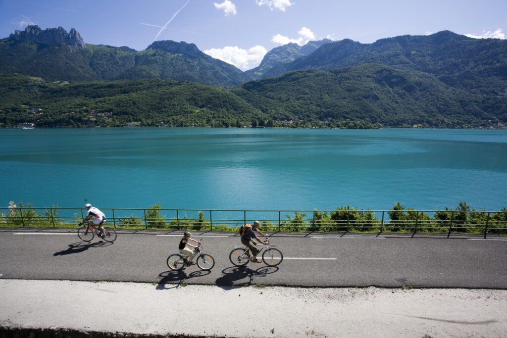 Cyclists ride along the bike path next to Lake Annecy